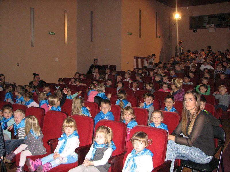 zdjęcie dzieci siedzących w na krzesłach widowni w teatrze
